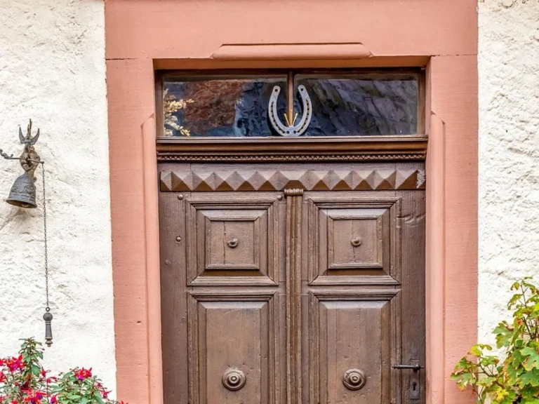 Solid wood paneled entry door with raised panels in a stone frame