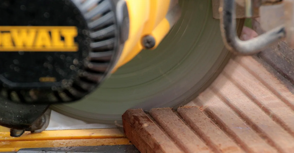 10-inch miter saw blade cutting through a wood board close up