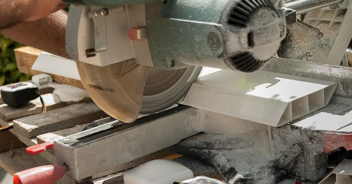 Sliding miter saw cutting a board in a workshop