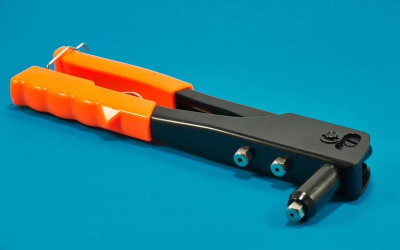 Hand riveter tool with orange handles Hand riveter tool with orange handles