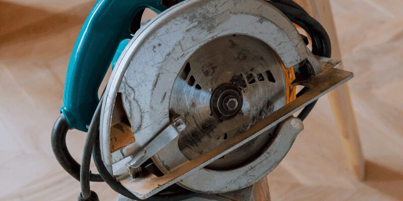 Circular saw mid-cut through a wood board at an angle