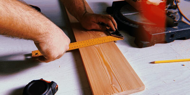 push block guiding a narrow board through a table saw for a beveled edge cut