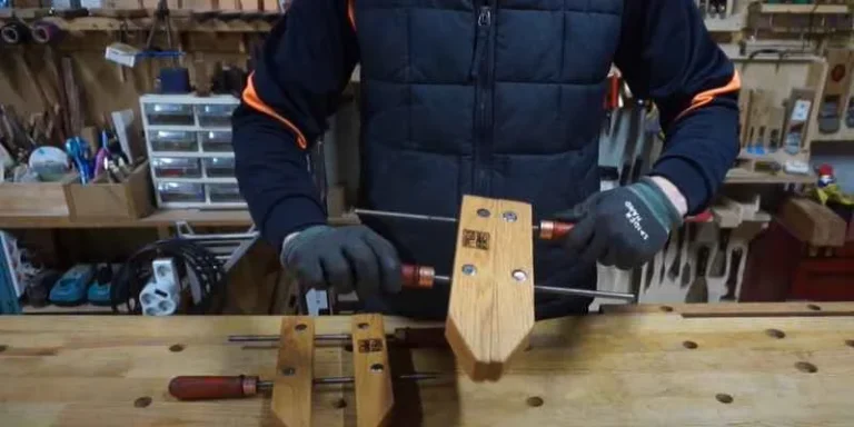 Woodworker assembling a wooden handscrew clamp in a workshop