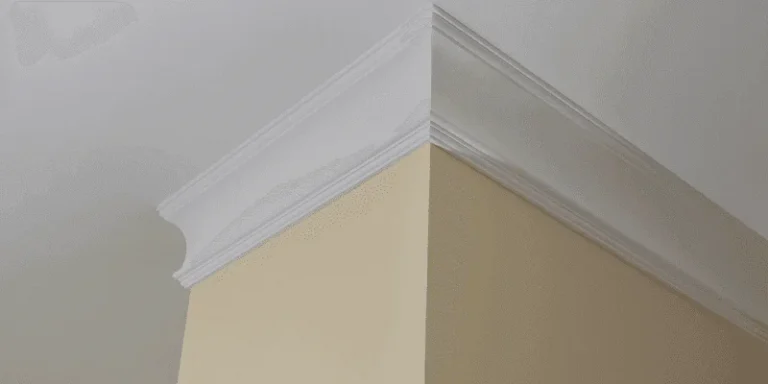 White crown molding mitered at an outside wall corner where the wall meets the ceiling