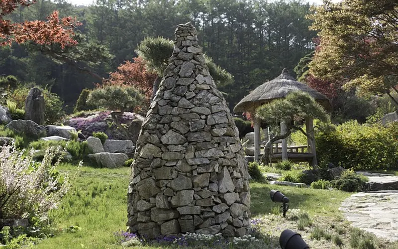 Stacked and bonded rocks forming a landscape cairn feature in a garden