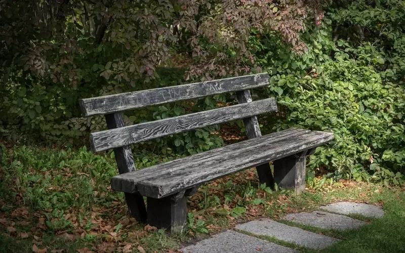Weathered outdoor wooden bench with silver-gray surface from sun and rain