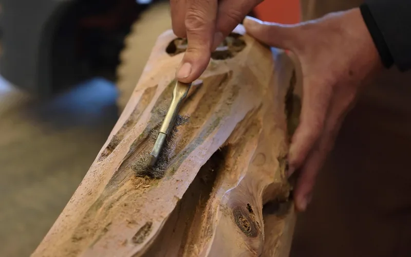 Carpenter inspecting a straight-grained wood blank before carving a wooden sword