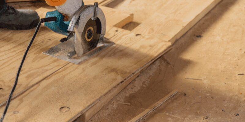 Circular saw blade cutting through a sheet of plywood Circular saw blade cutting through a sheet of plywood