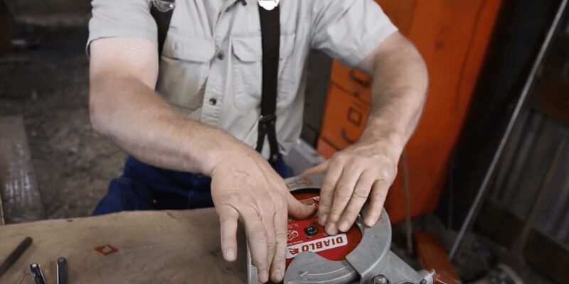 close-up of a technician checking blade alignment on a circular saw arbor