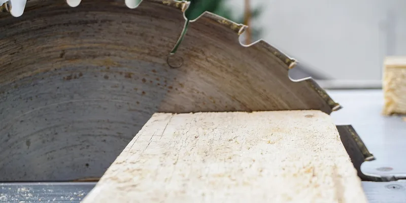 carbide-tip circular saw blade teeth cutting through a wood board carbide-tip circular saw blade teeth cutting through a wood board