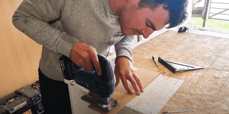 Jigsaw cutting cleanly through a melamine board with a fine-tooth blade