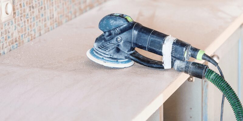 Random orbital sander on a large flat wood tabletop