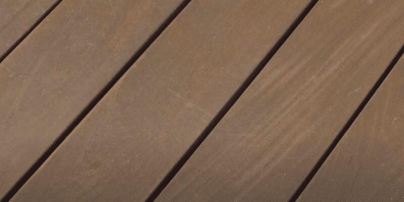 close-up of brown composite decking boards with diagonal grooved edges