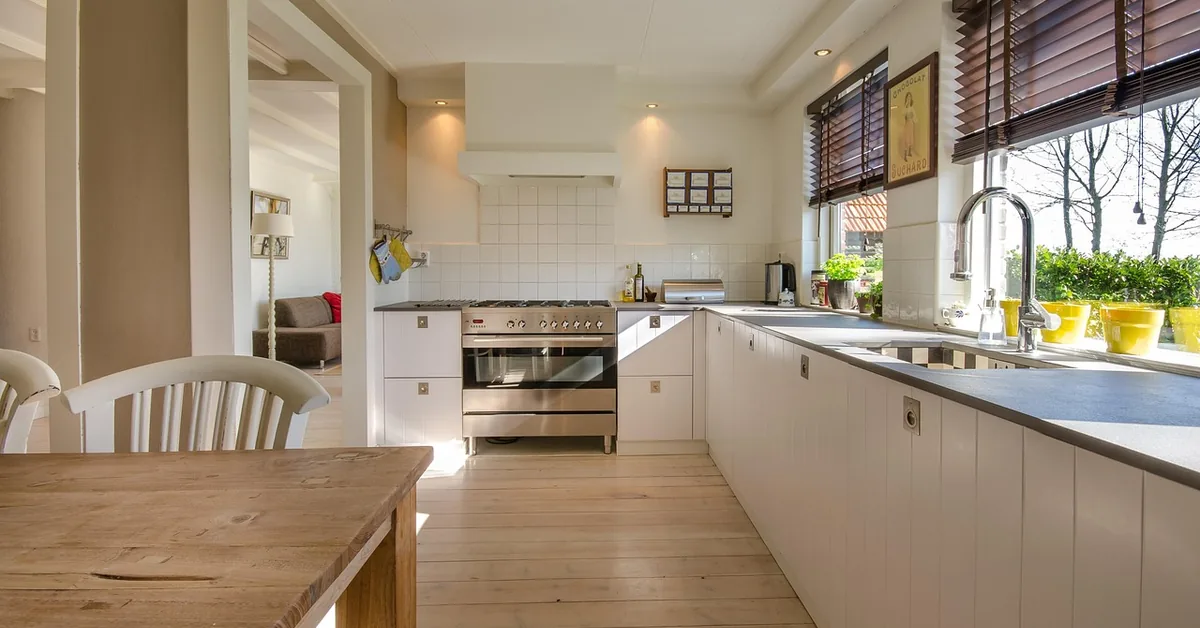 Light natural wood-tone plank flooring in a bright modern kitchen with white cabinets