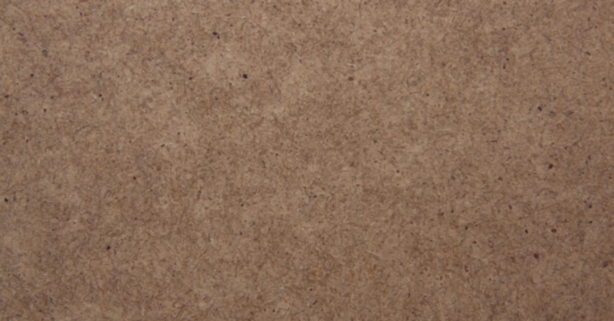 Close-up of an MDF board surface showing fine compressed wood fibers and no grain