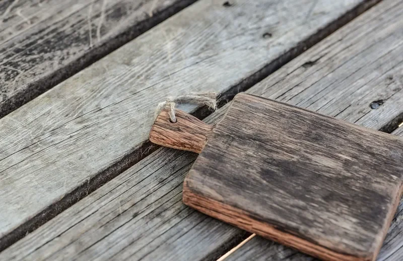 Small rustic wooden cutting board on weathered planks