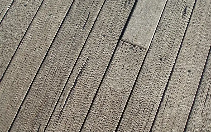 Weathered gray deck boards with checking and raised grain Weathered gray deck boards with checking and raised grain