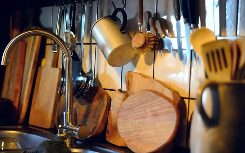 Wooden cutting boards standing on edge beside a kitchen sink to air-dry Wooden cutting boards standing on edge beside a kitchen sink to air-dry