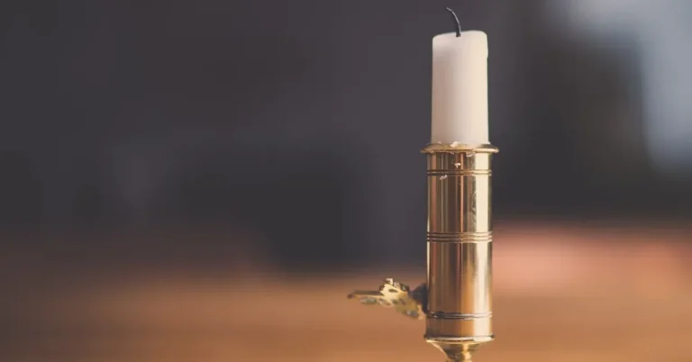 Candle in a brass holder on a wooden table