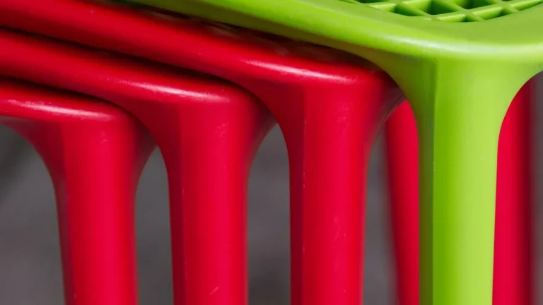 Close-up of stacked red and green molded plastic chairs, the kind of surface Citristrip is not recommended for
