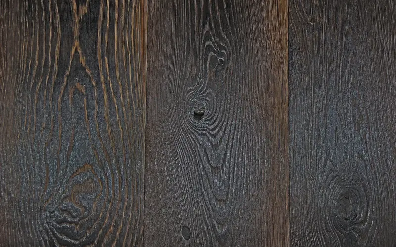 close-up of dark stained wood grain showing deep contrast dye adds over a torched surface