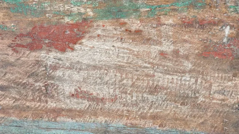 worn teal and red paint layers on old wood showing a distressed finish