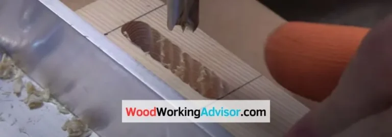 Drill bit cutting a slotted hole into a wood board