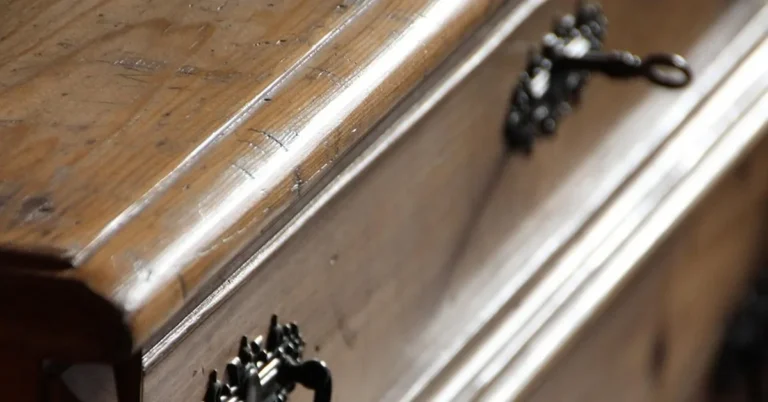 Close-up of a wooden drawer front with metal pull attached to a cabinet