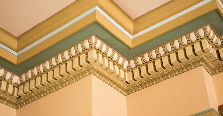 Inside corner of ornate crown molding showing a coped joint fit