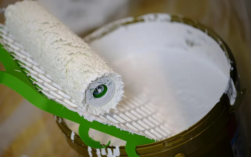 foam roller loaded with finish resting in a paint tray foam roller loaded with finish resting in a paint tray