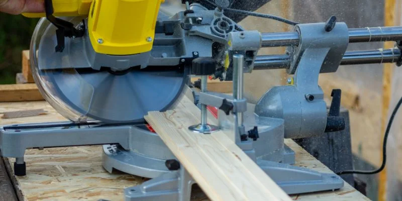 Close-up of a compound miter saw blade cutting through a wood board