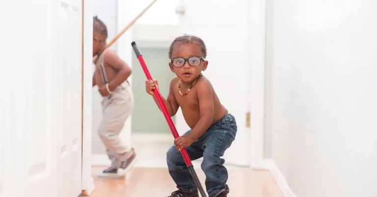 Child mopping a sealed wood floor in a hallway with a microfiber flat mop