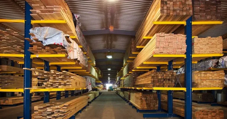 Stacked plywood sheets and lumber stored flat on warehouse racks to prevent warping