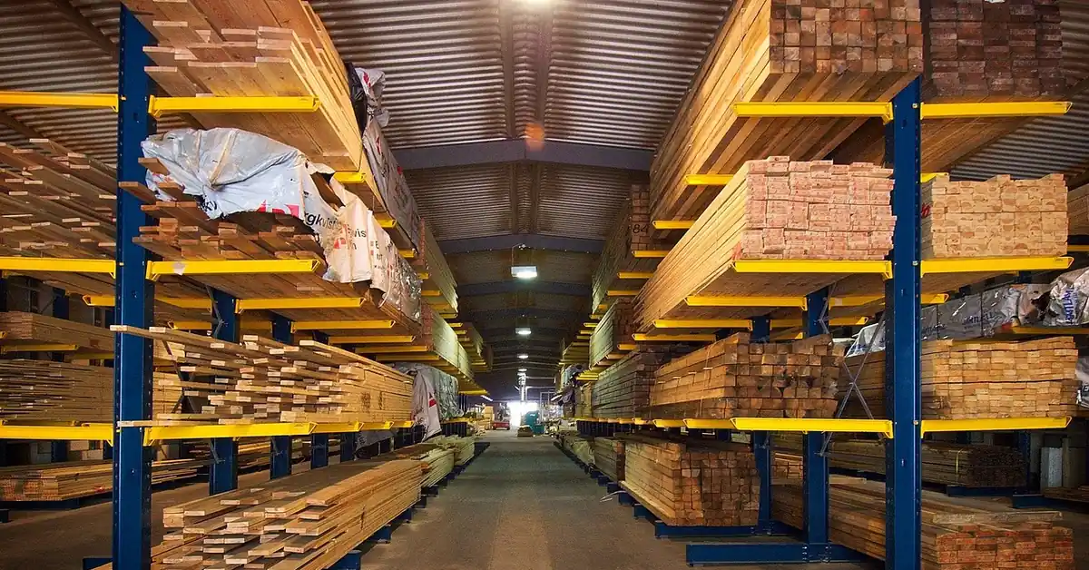 Stacked plywood sheets and lumber stored flat on warehouse racks to prevent warping