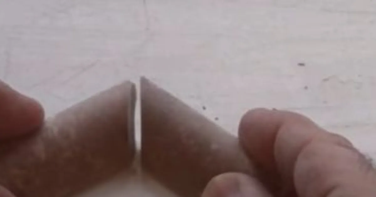 Carpenter's hands fitting mitered quarter-round trim pieces at an inside corner joint