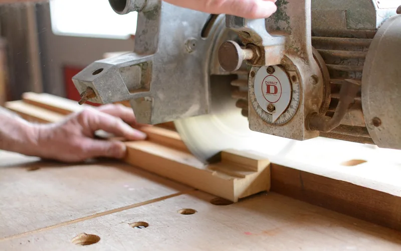 Vintage radial arm saw in a woodworking workshop -- inspect carriage travel, arm detents, and blade guard before buying used