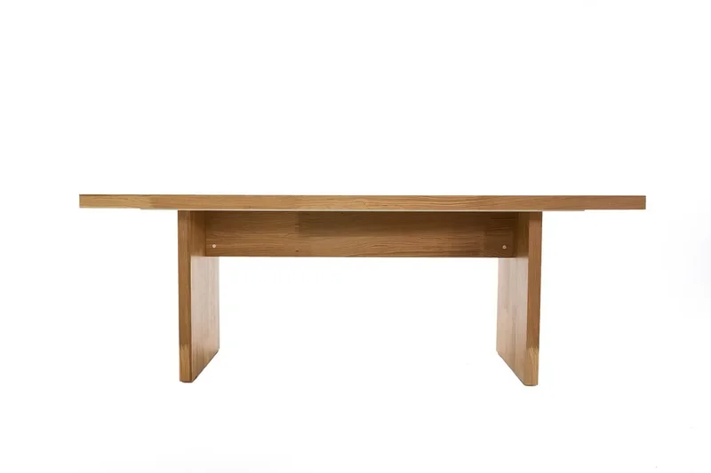Solid wood dining table with slab legs against a white background