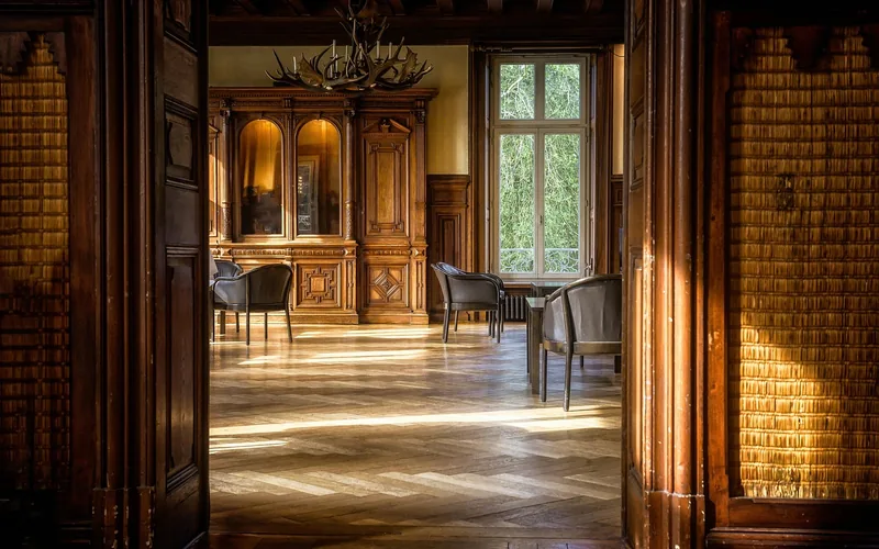 Sunlit wood floor showing direct UV exposure Sunlight streaming across a wood parquet floor through a large window