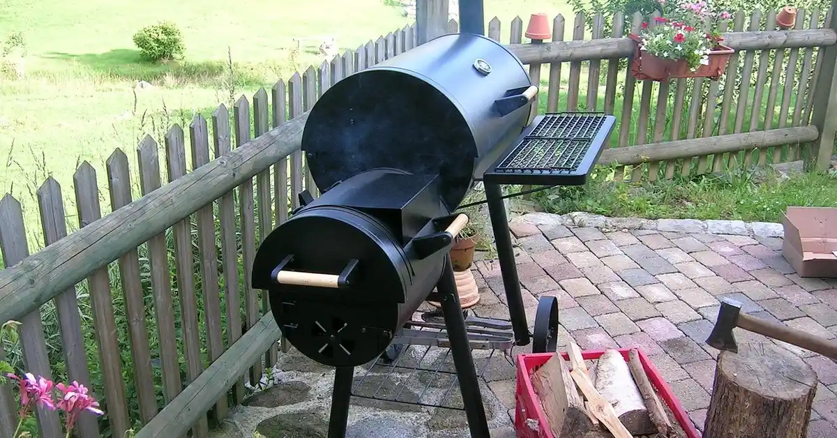 Offset smoker with pecan wood chunks in a crate for smoking meat