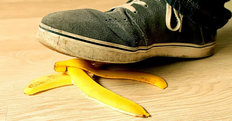 Banana peel and sneakers on a slippery wood floor showing a fall hazard