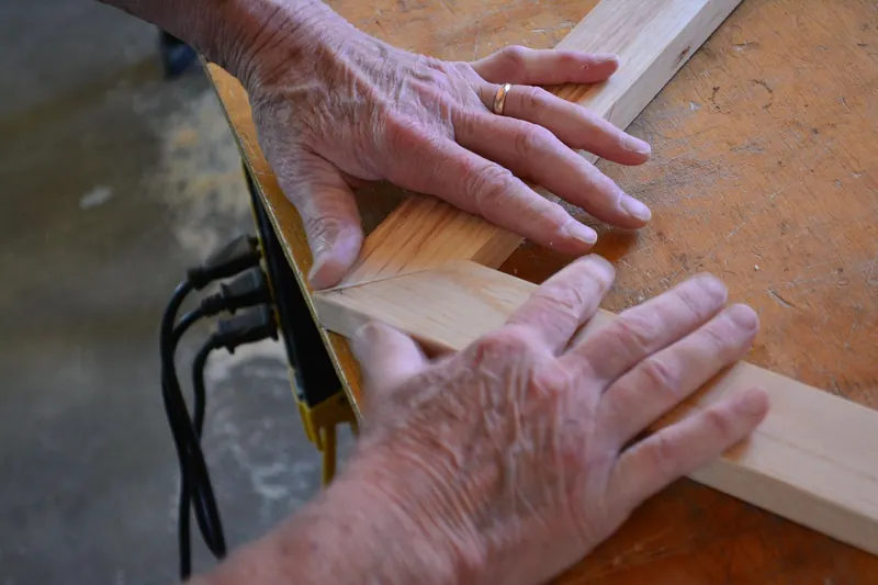 Hands aligning a stile and rail at a frame corner on a workbench