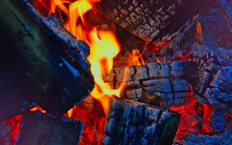 backyard fire pit with wood logs burning at night