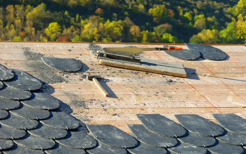 carpenter marking and cutting an individual roof rafter on site during stick framing