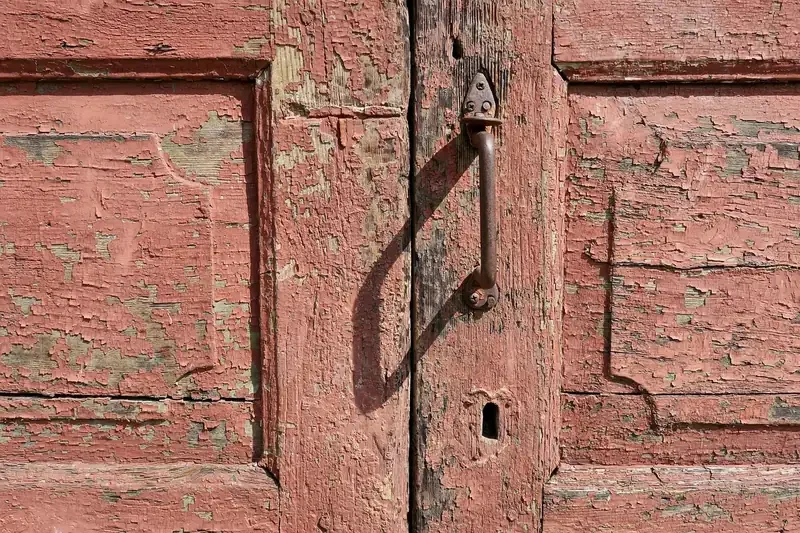 Cracked and peeling coating on an old weathered wooden door
