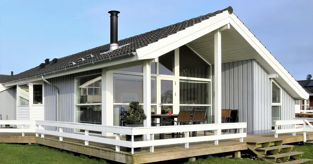 House with white painted exterior trim, fascia and porch posts against gray siding