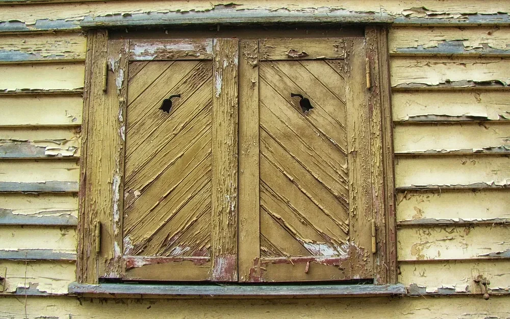 peeling paint on old wood siding and window trim showing coating failure peeling paint on old wood siding and window trim showing coating failure