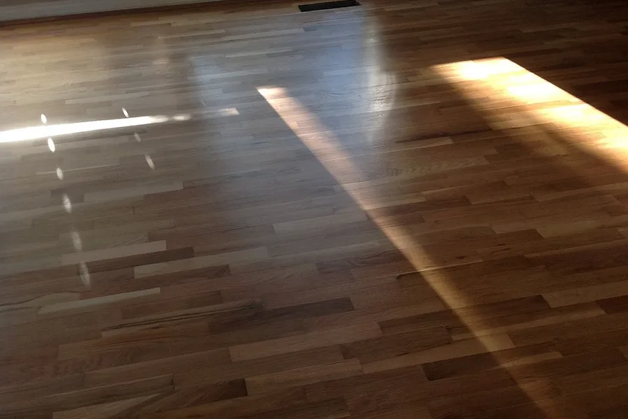 hardwood floor planks with sunlight from a window falling across them