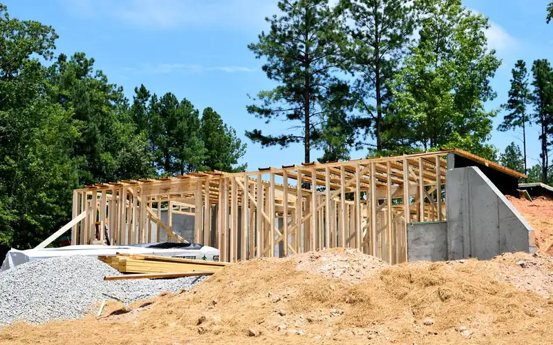 wood stud wall framing on a house under construction with an unfinished door opening wood stud wall framing on a house under construction with an unfinished door opening