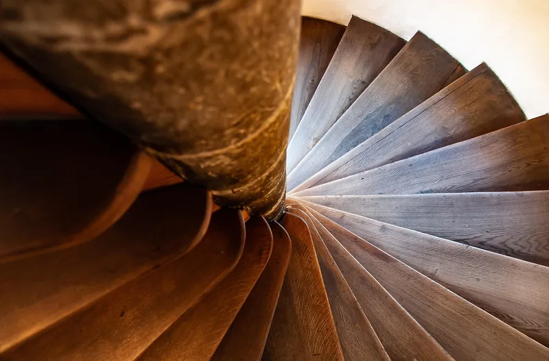 Light wood stair treads fanning around a spiral staircase