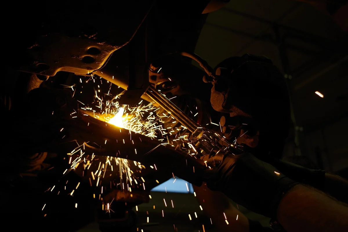 Oxy-acetylene torch cutting through metal with bright sparks